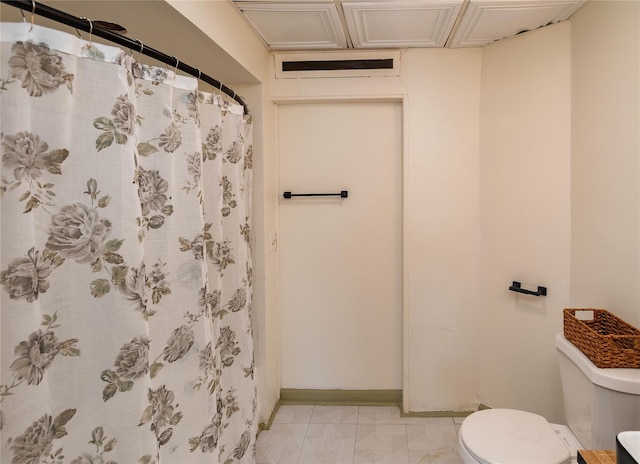 bathroom with a shower with curtain, baseboards, and toilet