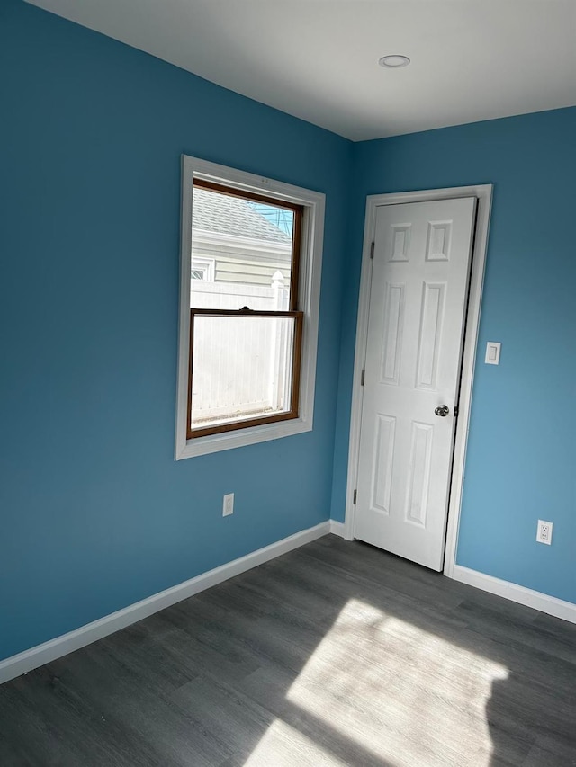 spare room with wood finished floors and baseboards