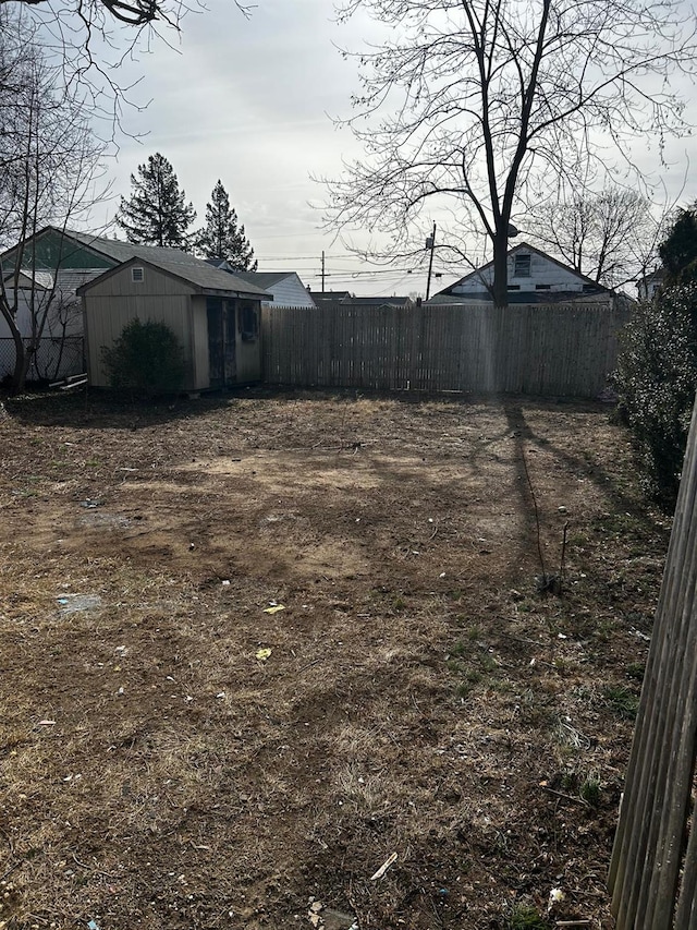 view of yard featuring a shed, an outdoor structure, and fence