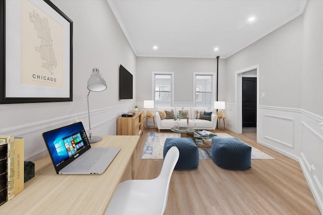 living area featuring a wainscoted wall, crown molding, recessed lighting, a decorative wall, and light wood-style floors