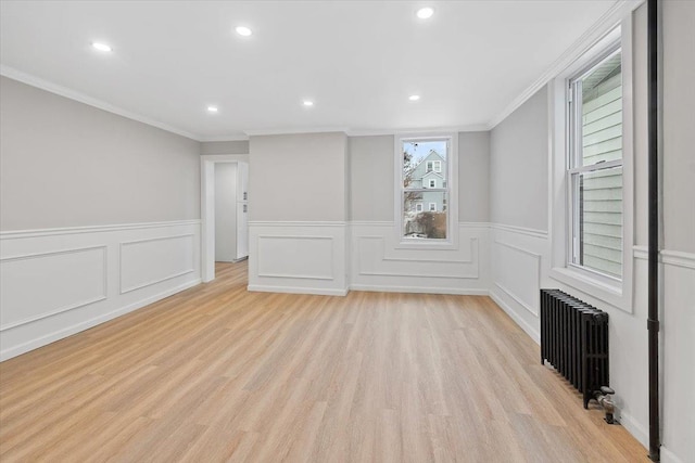 spare room with radiator, light wood-style floors, crown molding, and recessed lighting