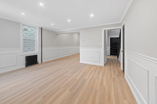 unfurnished living room with radiator, light wood-style flooring, crown molding, and recessed lighting