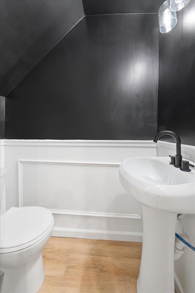 bathroom featuring a sink, wood finished floors, and toilet