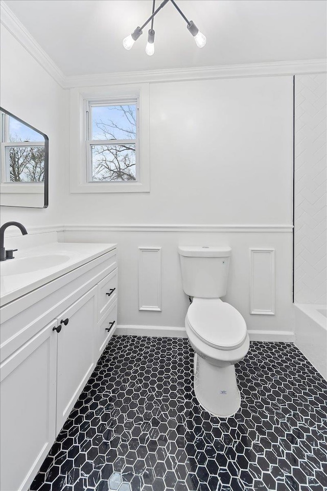 bathroom with toilet, crown molding, and vanity