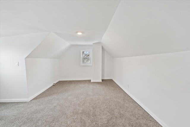 additional living space with carpet, vaulted ceiling, and baseboards