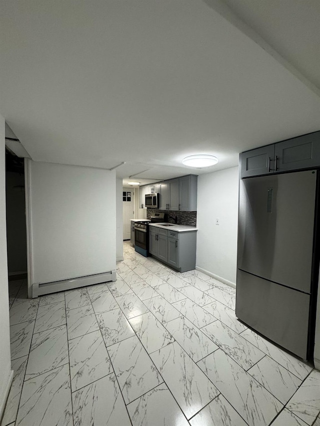 kitchen featuring stainless steel appliances, a baseboard radiator, marble finish floor, and light countertops