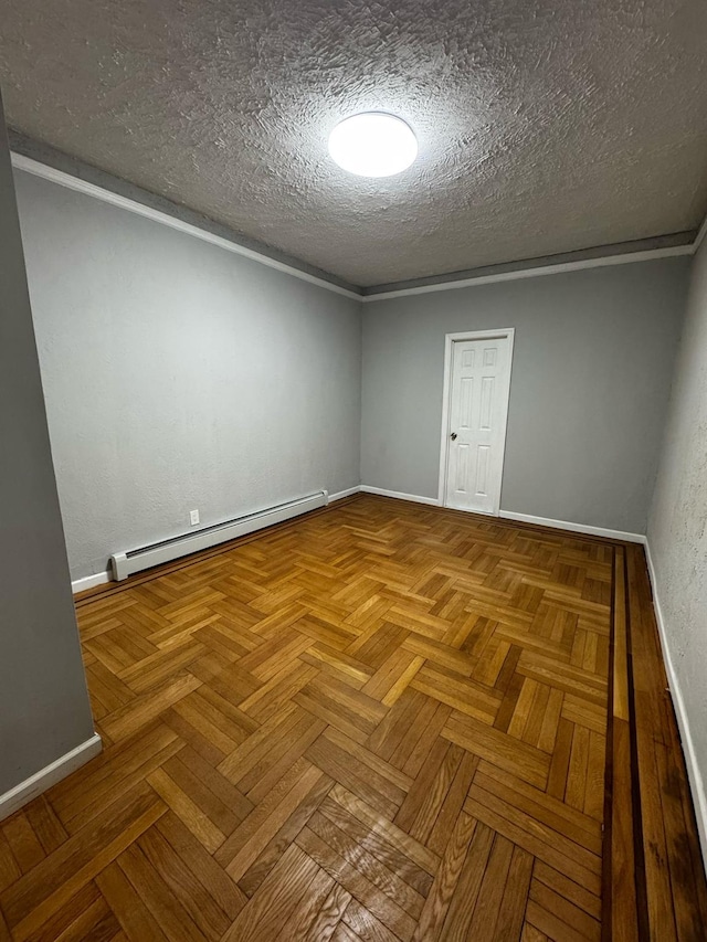 spare room featuring a baseboard radiator, a textured ceiling, and baseboards