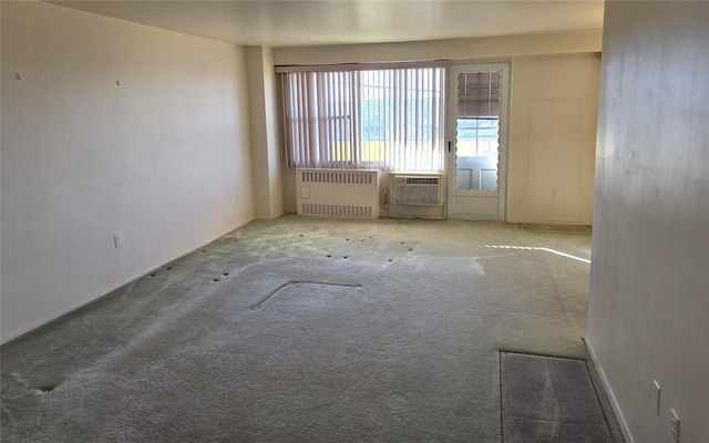 unfurnished room with baseboards, carpet floors, and radiator