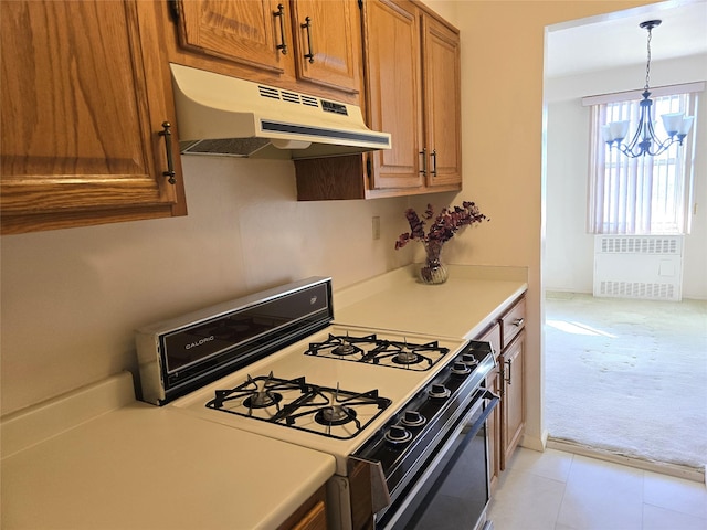 kitchen with range with gas stovetop, radiator heating unit, light countertops, under cabinet range hood, and light carpet