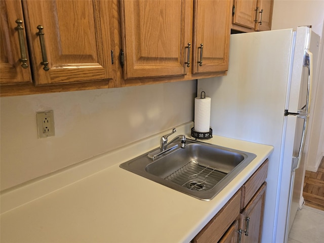 kitchen featuring a sink, brown cabinets, and light countertops