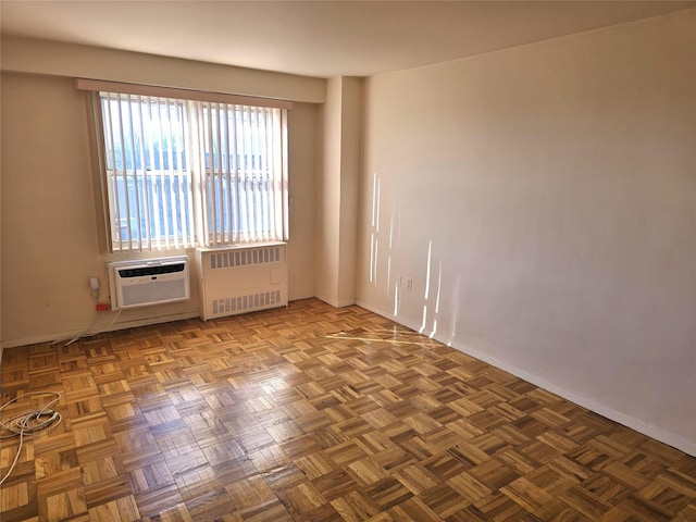 empty room featuring a wall mounted air conditioner and radiator heating unit