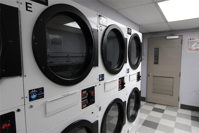 common laundry area with stacked washer and dryer, light floors, and washing machine and clothes dryer