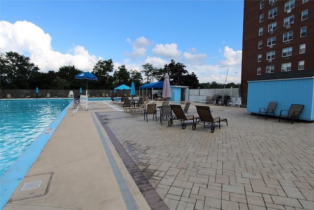 pool with a patio area and fence