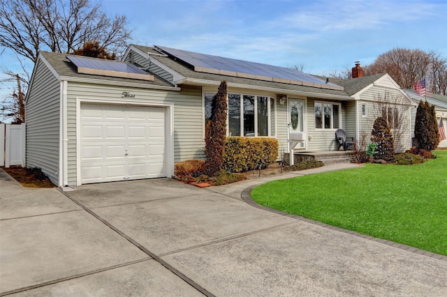 single story home featuring a garage, a front yard, concrete driveway, and solar panels