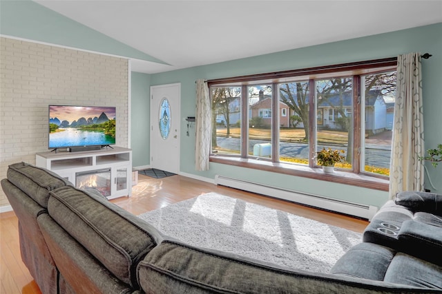 living area with a baseboard heating unit, vaulted ceiling, and wood finished floors