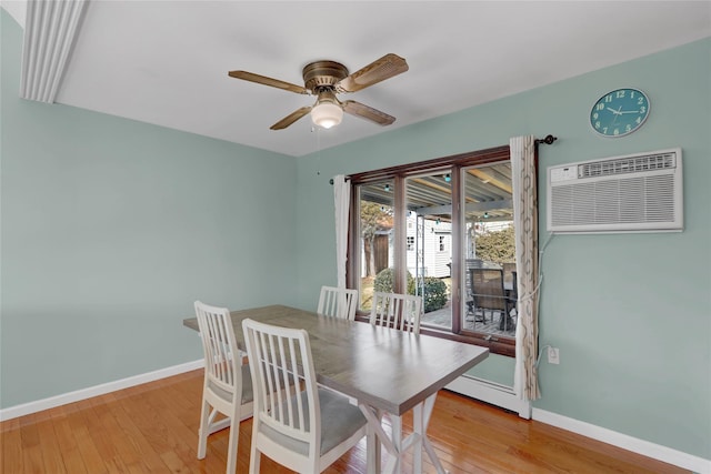 dining space featuring ceiling fan, an AC wall unit, light wood-type flooring, and baseboards