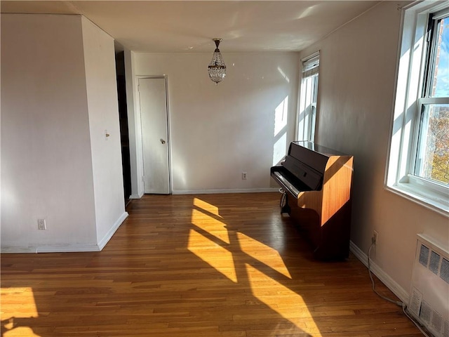 interior space featuring radiator, plenty of natural light, baseboards, and dark wood-style flooring