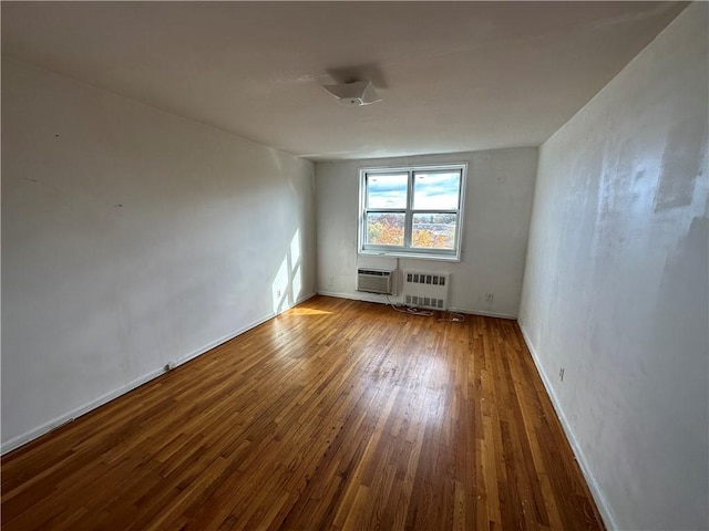 spare room featuring radiator heating unit and wood finished floors
