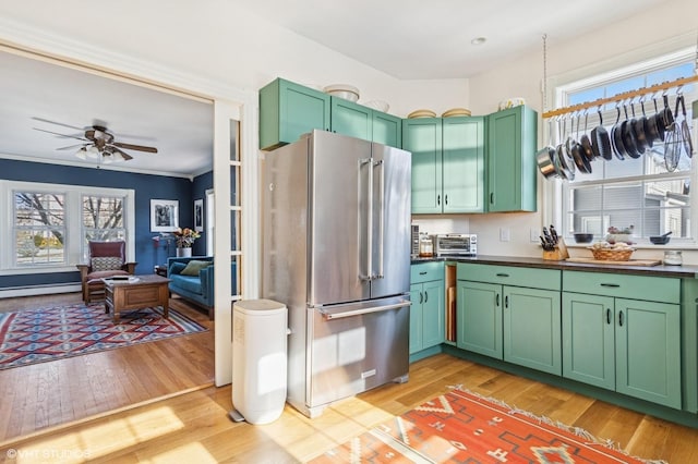 kitchen with green cabinets, high quality fridge, and dark countertops