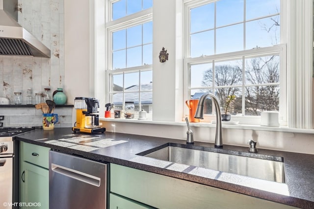 kitchen with wall chimney range hood, a healthy amount of sunlight, and green cabinetry