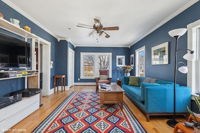 living room featuring baseboards, ceiling fan, wood finished floors, baseboard heating, and crown molding