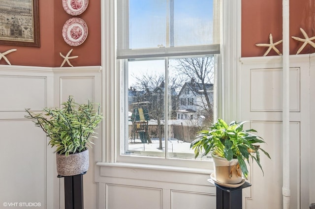 entryway with wainscoting and a decorative wall