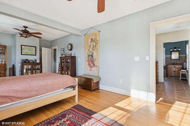 bedroom featuring a ceiling fan, baseboards, and wood finished floors