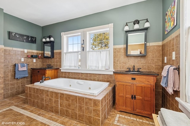 bathroom with a whirlpool tub, tile walls, vanity, and tile patterned floors