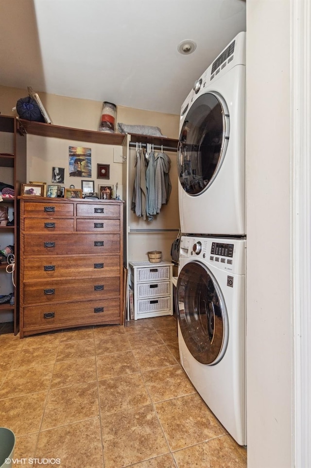 laundry room featuring stacked washer and dryer, laundry area, and light tile patterned floors