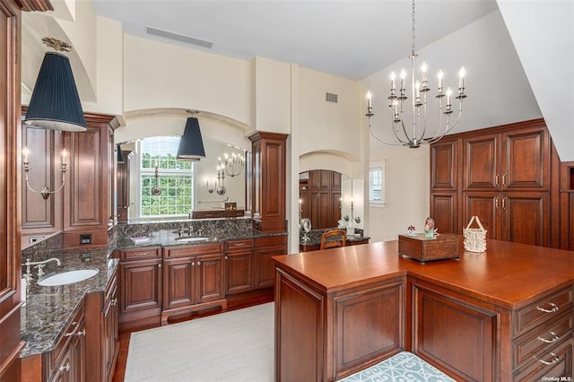 interior space with arched walkways, a notable chandelier, a sink, and visible vents