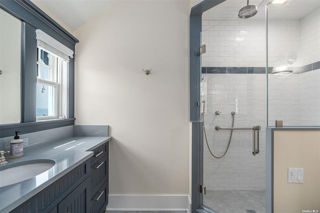 bathroom featuring a shower stall, baseboards, and vanity