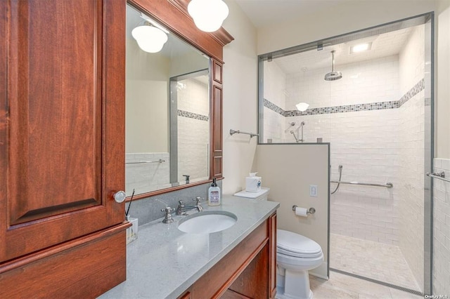 bathroom with a stall shower, vanity, and toilet