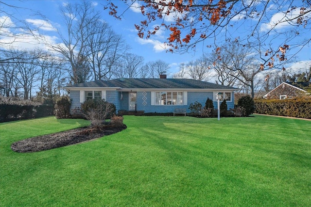 single story home featuring a chimney and a front lawn