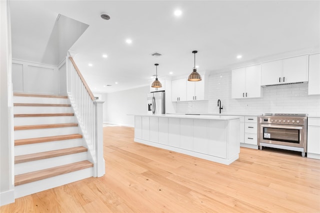 kitchen featuring visible vents, light countertops, white cabinets, appliances with stainless steel finishes, and light wood-type flooring