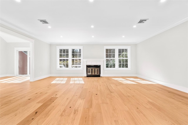 unfurnished living room with visible vents, a fireplace with flush hearth, and plenty of natural light