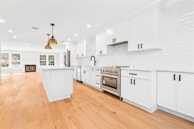 kitchen with visible vents, tasteful backsplash, stainless steel appliances, light wood finished floors, and light countertops