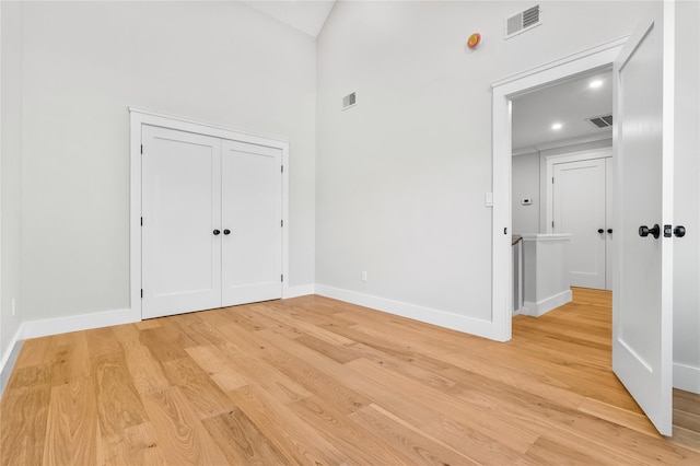 empty room with baseboards, visible vents, and light wood-type flooring