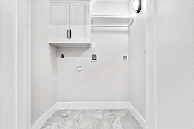 washroom with cabinet space, hookup for an electric dryer, hookup for a washing machine, and baseboards