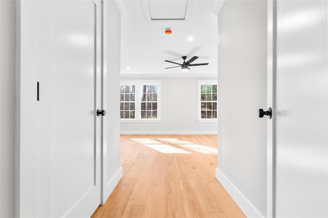 hall with baseboards and light wood-style floors