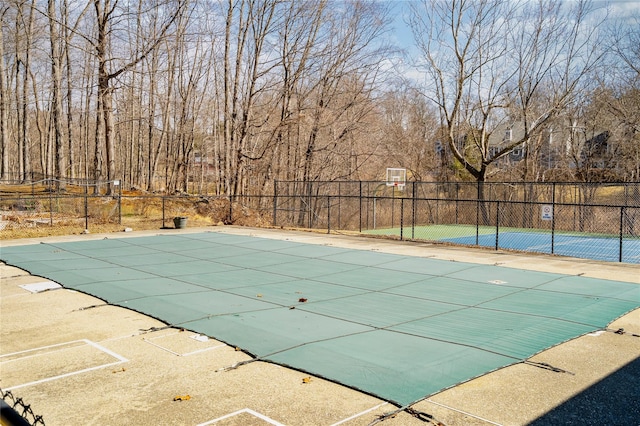 view of pool featuring a fenced in pool, community basketball court, and fence