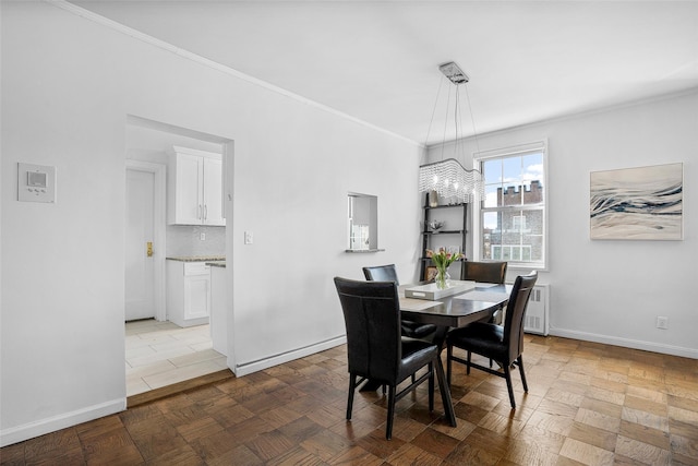 dining room featuring baseboards, an inviting chandelier, and crown molding