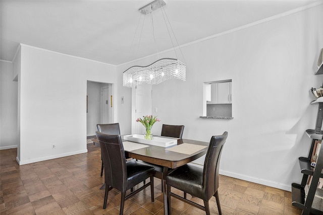 dining room with baseboards, a notable chandelier, and crown molding