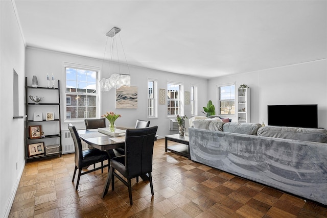 dining area with a chandelier, baseboards, and radiator heating unit