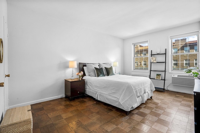 bedroom featuring radiator, a wall unit AC, and baseboards