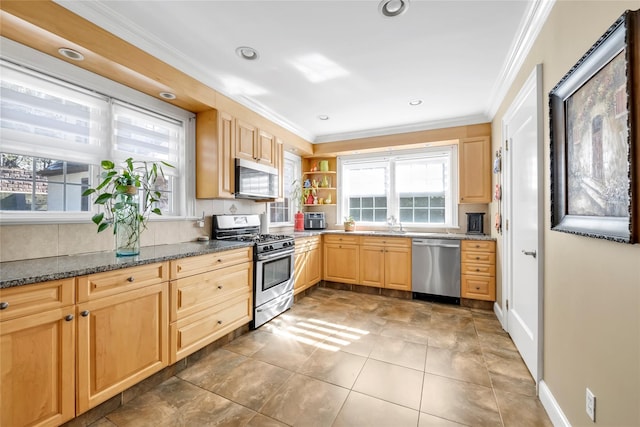 kitchen with stainless steel appliances, decorative backsplash, light brown cabinetry, ornamental molding, and dark stone countertops