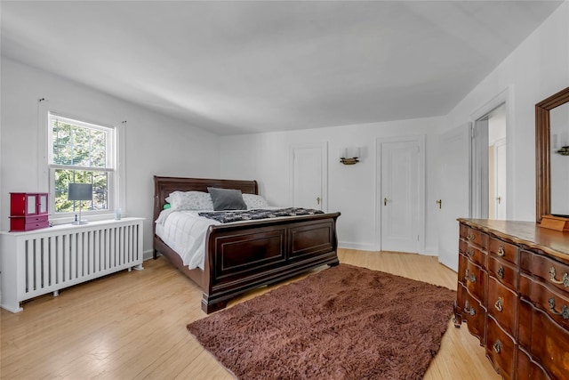 bedroom featuring light wood-type flooring and radiator heating unit