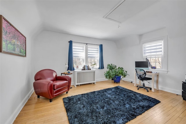 office featuring plenty of natural light, attic access, radiator heating unit, and wood finished floors