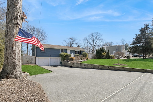 view of front of home with driveway, a garage, fence, and a front yard