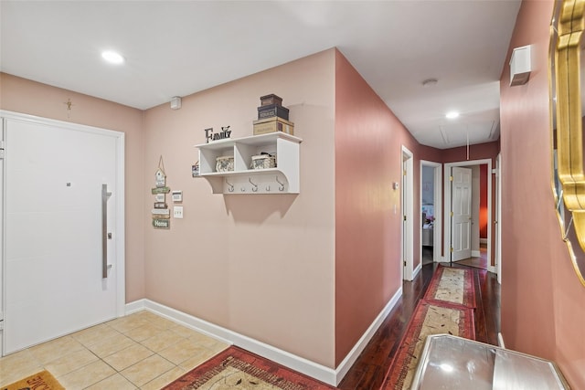 hallway with attic access, recessed lighting, baseboards, and tile patterned floors