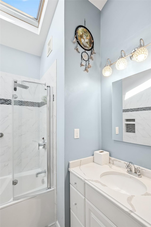 bathroom with a skylight, enclosed tub / shower combo, visible vents, and vanity